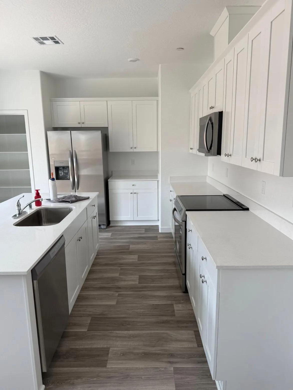 Clean white kitchen with spotless quartz countertops and stainless appliances after a Scrubhub house clean in Clovis, CA