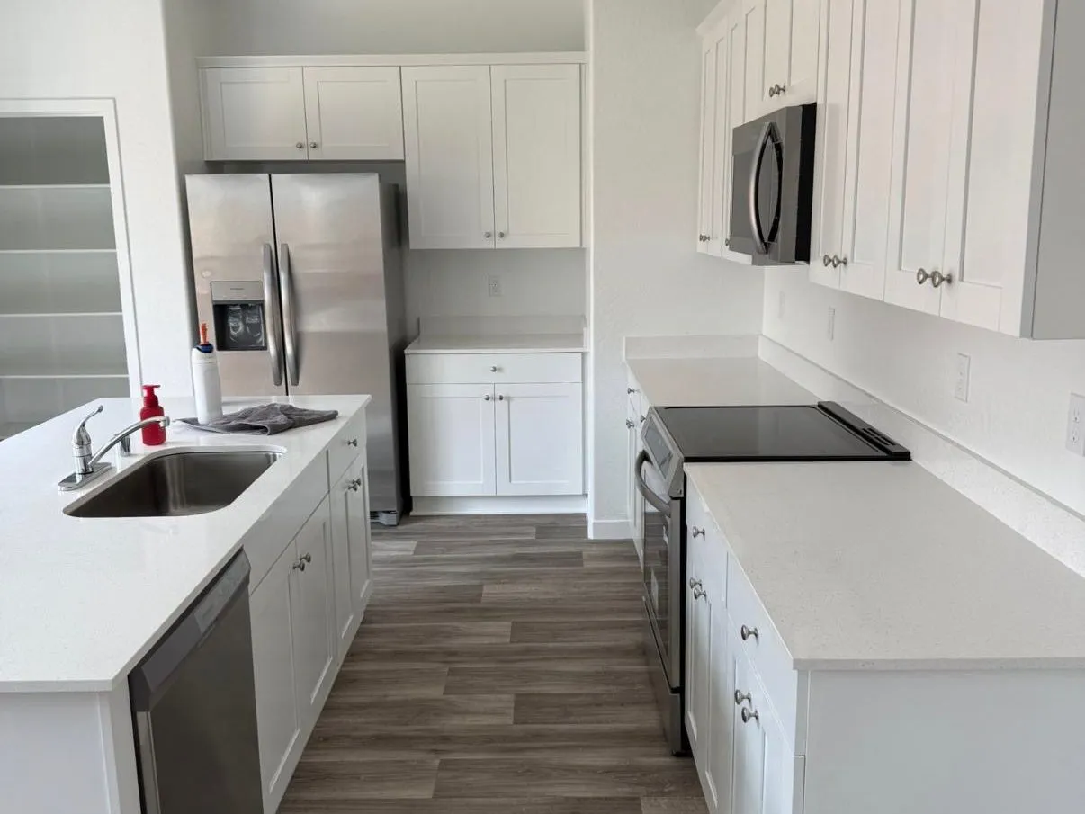 Clean white kitchen with spotless quartz countertops and stainless appliances after a Scrubhub house clean in Clovis, CA